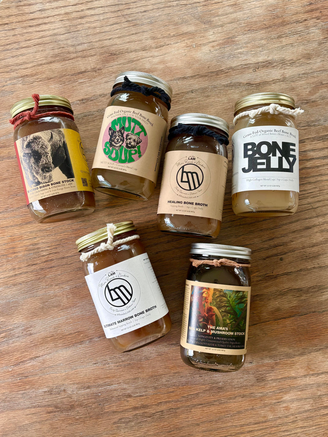 Collection of Organic Bone Broth in jars on a wooden surface